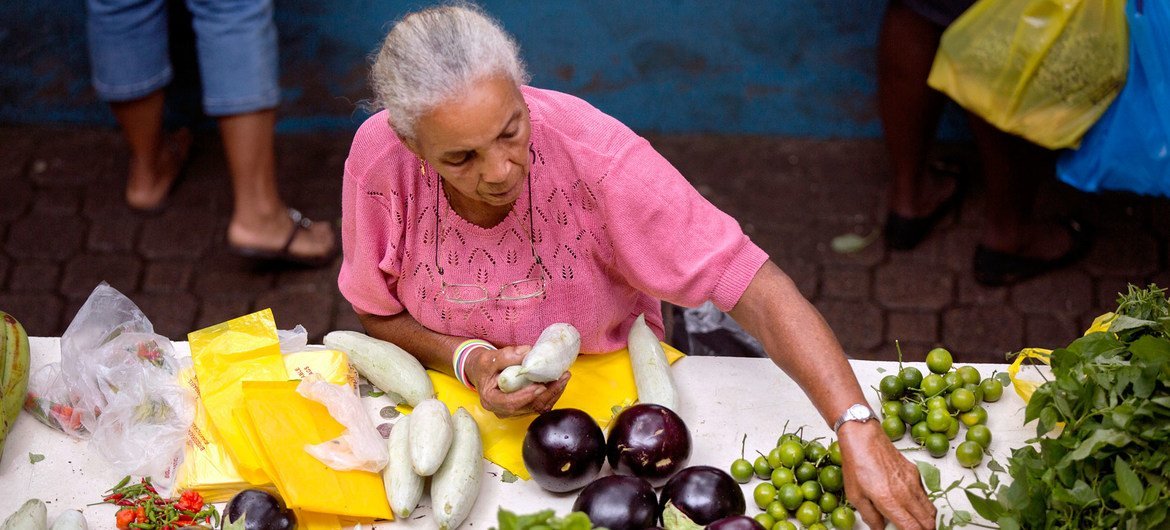 A woman sells vegetables in a market in Seychelles. Despite ongoing efforts, progress toward achieving several SDGs — including those on women's empowerment – remains off track for 2030.