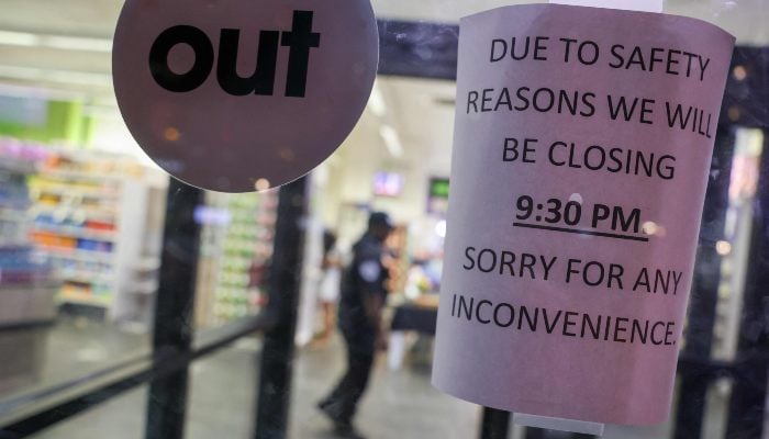 A sign in a store window alerts customers to the business closing as police work at the scene of a nearby fatal shooting in midtown Manhattan on July 28, 2025 in New York City, US. — AFP