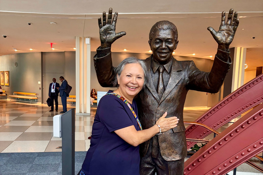 Brenda Reynolds, a recipient of the 2025 United Nations Nelson Rolihlahla Mandela Prize, poses with a statute of the late South African President at UN Headquarters in New York.