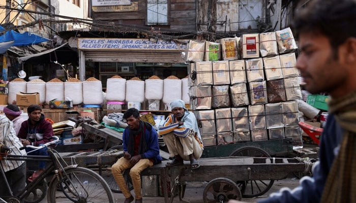 Workers sit on a cart at a wholesale market in the old quarters of Delhi, India. — Reuters/File