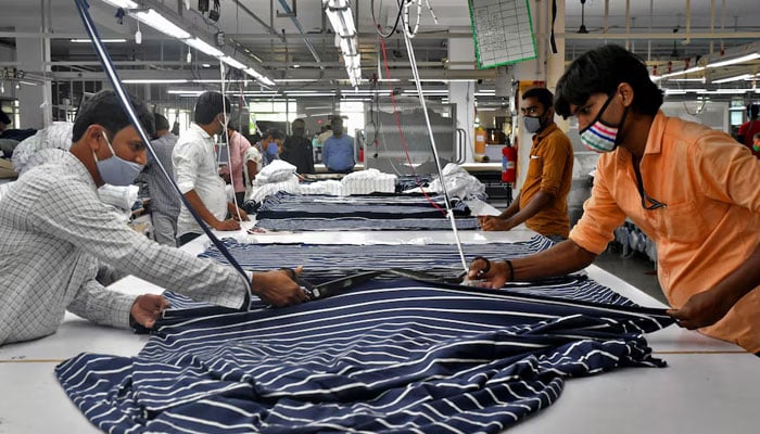 Garment workers cut fabric to make shirts at a textile factory of Texport Industries in Hindupur town in the southern state of Andhra Pradesh, India. — Reuters/File