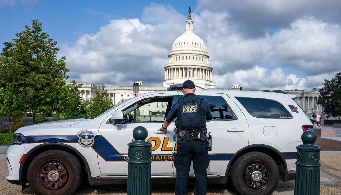 A police officer enters a police car near the US Capitol in Washington, DC, on August 8, 2025. — AFP