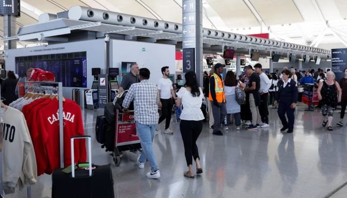 Stranded passengers walk as Air Canada flight attendants protest amid a standoff with a government board that said the stoppage was unlawful, at Toronto Pearson International Airport in Mississauga, Ontario, Canada August 18, 2025. — Reuters