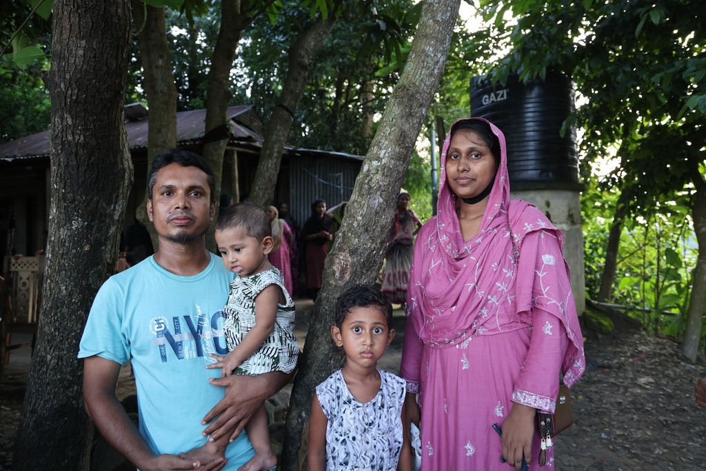 Anima Akhter, 24, with her husband Ruhul Amin, 30, a steelworker, and their two children outside their home in Bodipur village in Kurban Nagar Union.