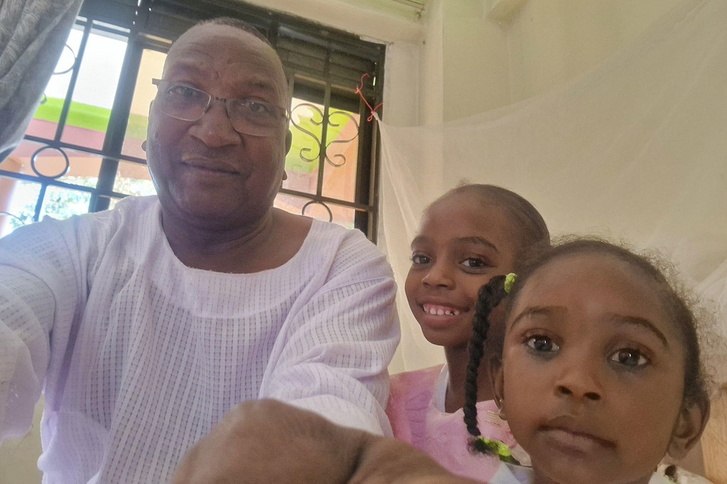 Adam with two of his daughters in Uganda.