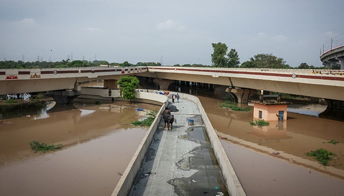 People walk across a bridge after a rise in the water level of river Yamuna due to heavy monsoon rains, in New Delhi, India, September 3, 2025. — Reuters