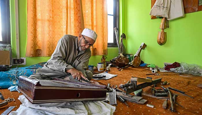 Artisan Ghulam Mohammad Zaz makes the Santoor instrument at his home in Srinagar, IIOJK on September 23, 2025. — AFP