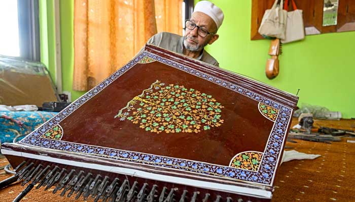 Artisan Ghulam Mohammad Zaz makes the Santoor instrument at his home in Srinagar, IIOJK on September 23, 2025. — AFP