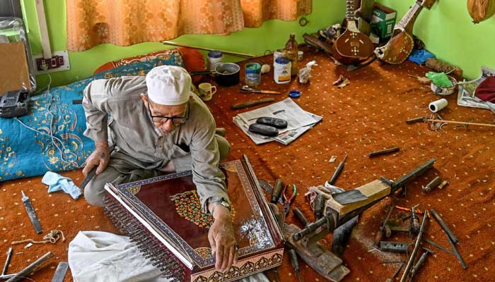Artisan Ghulam Mohammad Zaz makes the Santoor instrument at his home in Srinagar, IIOJK on September 23, 2025. — AFP
