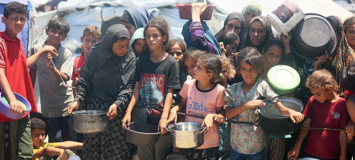 Families and children seeking food from a community kitchen in western Gaza City in late July. (file)
