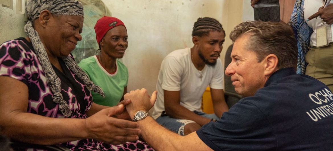 The UN's relief coordinator, Tom Fletcher, meets a family in Port-au-Prince, Haiti.