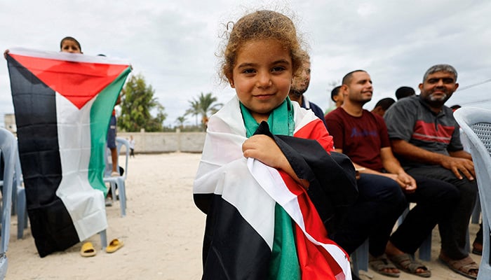 A girl holds a Palestinian flag, after U.S. President Donald Trump announced that Israel and Hamas agreed on the first phase of a Gaza ceasefire, in the central Gaza Strip October 9, 2025. — Reuters