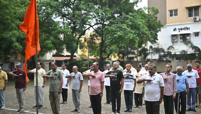 Rashtriya Swayamsevak Sangh (RSS) volunteers salute the organisation´s flag before morning drills during a shakha, or training session, of the Hindu nationalist organisation at a park in Nagpur on October 3, 2025. — AFP