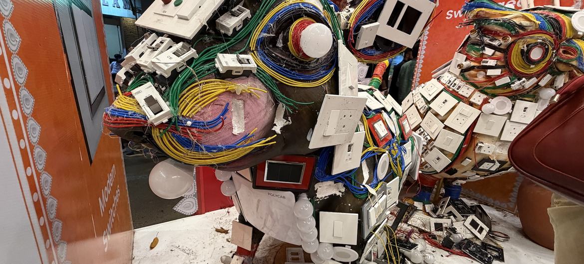 Figurines made with electronic waste material are displayed in a pandal or temple.