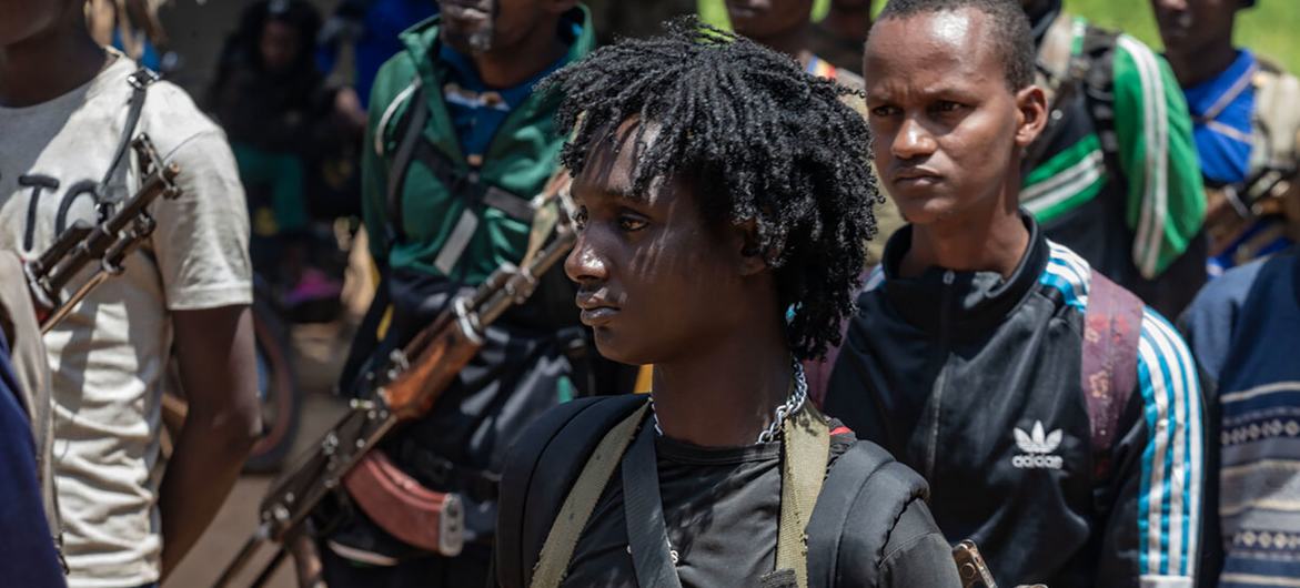 A young member of an armed group in the Central African Republic prepares to hand in his weapon.