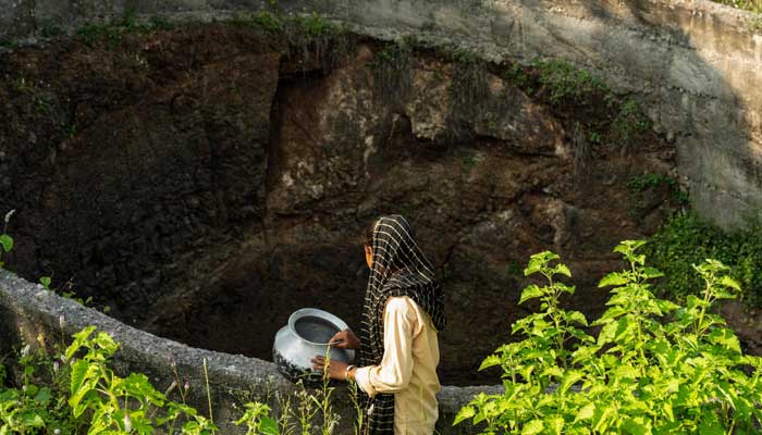 Ramati Mangla, who dropped out of school to manage household chores, looks to fetch water from a dried-up well at Bhadal village in the drought-prone district of Nandurbar on September 25, 2025. â AFP