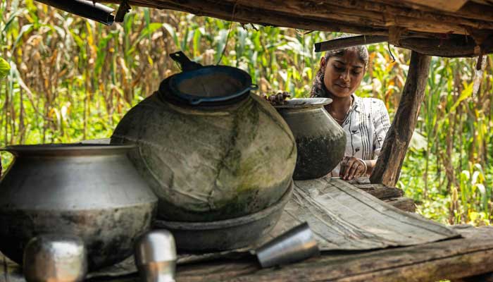 Ramati Mangla, who dropped out of school to manage household chores, checks the water stored in pots at her home in Bhadal village, in the drought-prone district of Nandurbar on September 25, 2025. â AFP