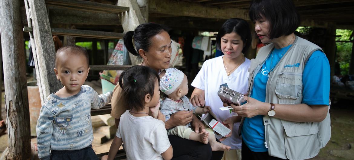 A UNICEF staff member hands ready to eat food to a family in Tuyên Quang, Viet Nam.