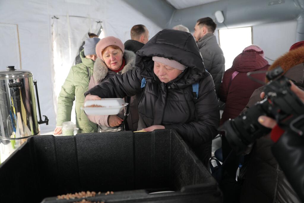 In Boryspil, Ukraine, on 14 January 2026, humanitarian workers and local authorities distribute food to vulnerable people enduring extreme winter conditions with temperatures below -10°C.