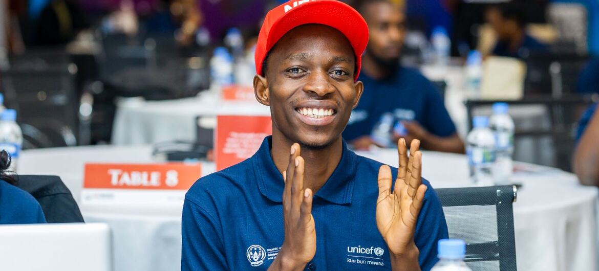 Jacques Kwibuka, a UNICEF volunteer, claps enthusiastically at an education network event.