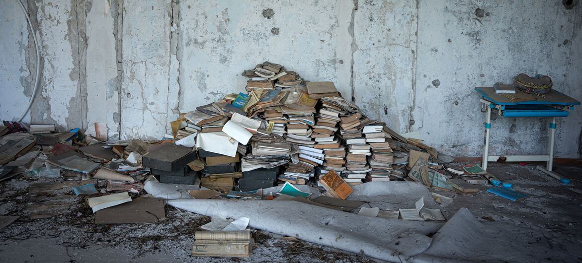 Damaged books are piled up inside a destroyed classroom in Kherson, Ukraine