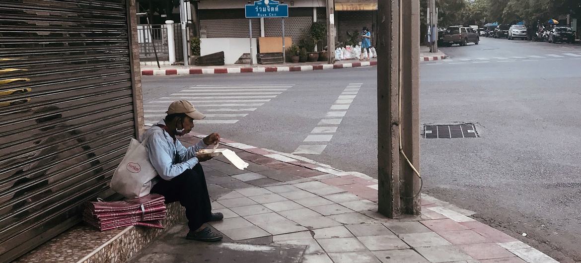 Eating in a deserted street in Bangkok, Thailand during COVID-19 lockdown times.