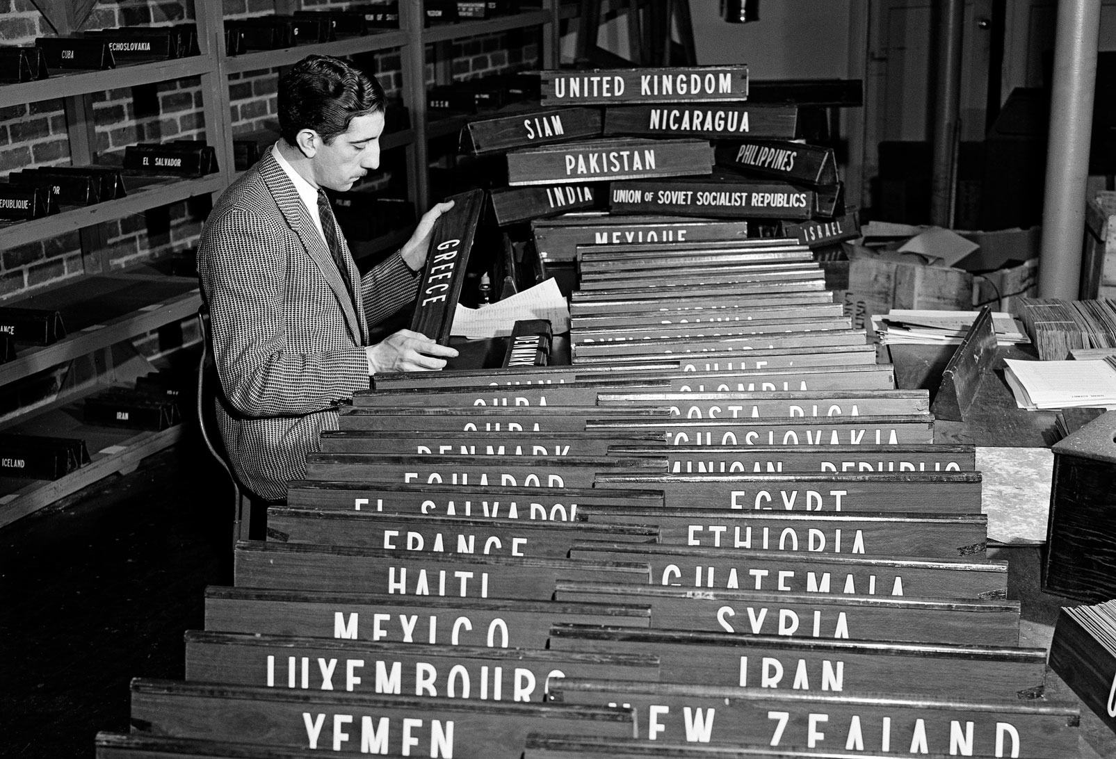 A UN staff member checks the nameplates for the countries participating in the UN General Assembly at Flushing Meadow.